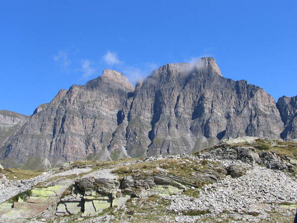 Eine felsige Berglandschaft mit imposanten Gipfeln unter einem klaren, blauen Himmel.